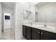 Clean bathroom with double vanity, mirror, and access to another room at 2084 N 214Th Dr, Buckeye, AZ 85396