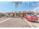 Single-story home with carport, gravel yard, and red car parked at 131 W Tulsa St, Chandler, AZ 85225