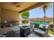 Outdoor kitchen and patio with fire pit and pool view at 4809 E Fire Opal Ln, San Tan Valley, AZ 85143