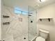 Spa-like bathroom with marble tile, large shower, and built-in shelving at 4423 E Ponca St, Phoenix, AZ 85044