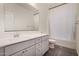 Bathroom with a bathtub, toilet, and vanity with gray cabinets at 19031 W Palo Verde Dr, Litchfield Park, AZ 85340