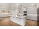 Open concept kitchen with island, stainless steel appliances, and white quartz countertops at 19031 W Palo Verde Dr, Litchfield Park, AZ 85340
