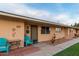 Front view of a light brown building with teal chairs and a table at 13671 N 111Th Ave, Sun City, AZ 85351