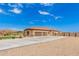 Home's exterior showcases a three-car garage and desert landscaping at 6786 W Gelding Ln, Coolidge, AZ 85128