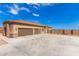 House exterior featuring a three-car garage and large driveway at 6786 W Gelding Ln, Coolidge, AZ 85128