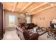 Living room with wood beam ceiling, fireplace and leather furniture at 6786 W Gelding Ln, Coolidge, AZ 85128
