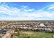 Aerial view showing a large neighborhood with houses, green spaces, and a pond at 41650 W Harvest Moon Dr, Maricopa, AZ 85138