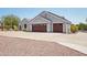 House exterior featuring a three-car garage and manicured landscaping at 23040 W Hammond Ln, Buckeye, AZ 85326