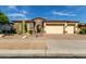 Tan stucco house with stone accents, three-car garage, and desert landscaping at 31811 N 16Th Ave, Phoenix, AZ 85085