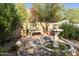 Peaceful courtyard with fountain, bench, and lush landscaping at 4754 E Valley Vista Ln, Paradise Valley, AZ 85253