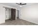 Bedroom with wood-look floors, ceiling fan and barn door closet at 6131 E Monterey Way, Scottsdale, AZ 85251