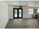 Dining room with gray floors and French doors opening to a patio and pool at 6131 E Monterey Way, Scottsdale, AZ 85251