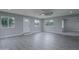 Spacious living room featuring gray vinyl flooring and large windows at 9614 W Greenhurst Dr, Sun City, AZ 85351