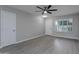 Bright living room with gray walls, wood-look floors, and a ceiling fan at 9614 W Greenhurst Dr, Sun City, AZ 85351