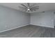 Bright living room with gray vinyl flooring and ceiling fan at 9614 W Greenhurst Dr, Sun City, AZ 85351