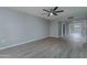 Open living room with gray walls, wood-look floors, and access to other rooms at 9614 W Greenhurst Dr, Sun City, AZ 85351