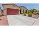 Front view of a house with red garage door and desert landscaping at 20285 N Winter Escape Ct, Maricopa, AZ 85138