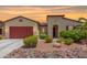 Single-story home with red garage door and landscaped front yard at 20285 N Winter Escape Ct, Maricopa, AZ 85138