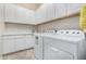 Laundry room with white cabinets and a washer and dryer at 20285 N Winter Escape Ct, Maricopa, AZ 85138