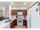 Modern kitchen with wood cabinets, white appliances, and a large island at 1560 E Melrose Dr, Casa Grande, AZ 85122