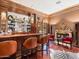 Stunning home bar with leather barstools and a fireplace at 40 Biltmore Est, Phoenix, AZ 85016