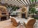 Relaxing patio with a stone fireplace, wicker chairs, and a pergola at 40 Biltmore Est, Phoenix, AZ 85016