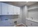 Bright laundry room with white cabinets and a sink at 16172 W Alameda Rd, Surprise, AZ 85387