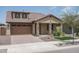 Tan house with a brown garage door and landscaping at 16172 W Alameda Rd, Surprise, AZ 85387