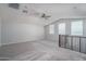 Spacious loft area with neutral carpeting and ceiling fan at 16172 W Alameda Rd, Surprise, AZ 85387