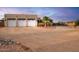 Three-car garage with white doors and desert landscaping at 19950 W Cambridge Ave, Buckeye, AZ 85396