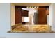 Partial view of kitchen with granite countertops and dark wood cabinets at 19950 W Cambridge Ave, Buckeye, AZ 85396