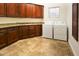 Laundry room with wood cabinets, granite counters, and washer/dryer at 19950 W Cambridge Ave, Buckeye, AZ 85396