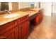 Bathroom with granite countertops, double sinks, and dark wood cabinets at 19950 W Cambridge Ave, Buckeye, AZ 85396