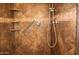 Walk-in shower with tiled walls, grab bar, and built-in shelves at 19950 W Cambridge Ave, Buckeye, AZ 85396