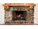 Stone fireplace with a wooden mantel and gas logs at 19950 W Cambridge Ave, Buckeye, AZ 85396