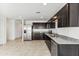 Modern kitchen with dark cabinets and granite countertops at 12313 E Aster Ln, Florence, AZ 85132