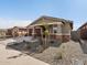 Modern house exterior with a two-car garage and stone accents at 16065 W Honeysuckle Dr, Surprise, AZ 85387