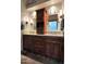 Double vanity bathroom with dark wood cabinets and a large mirror at 7514 E Oasis Cir, Mesa, AZ 85207