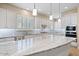 Spacious kitchen boasts a large island with granite countertops and white cabinetry at 25807 N 19Th Gln, Phoenix, AZ 85085