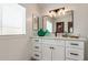 Modern bathroom with white cabinets, a quartz countertop, and a large mirror at 427 S 80Th Way, Mesa, AZ 85208