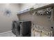 Convenient laundry room with washer, dryer, and shelving at 2126 W Red Fox Rd, Phoenix, AZ 85085