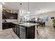 Open kitchen with granite island, dark cabinets and views to Gathering room at 2126 W Red Fox Rd, Phoenix, AZ 85085
