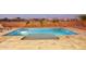 Luxury pool with a built-in tanning ledge and stone tile at 15175 S 185Th Ave, Goodyear, AZ 85338