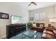 Gathering room with brown leather sofas, large TV, and ceiling fan at 15175 S 185Th Ave, Goodyear, AZ 85338