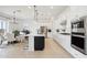 Modern kitchen with white cabinets, stainless steel appliances and large island at 15175 S 185Th Ave, Goodyear, AZ 85338