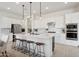 Modern kitchen with white cabinets, large island, and stainless steel appliances at 15175 S 185Th Ave, Goodyear, AZ 85338
