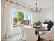 Bright dining room features a round table, white chairs, and large windows with backyard view at 15175 S 185Th Ave, Goodyear, AZ 85338