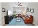 Cozy Gathering room features brown leather couches, a large TV, and ceiling fan at 15175 S 185Th Ave, Goodyear, AZ 85338