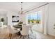 Dining room with a round table, white chairs, and window looking out to the pool at 15175 S 185Th Ave, Goodyear, AZ 85338