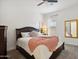 Bedroom with dark wood bed frame, pink blanket and full-length mirror at 15175 S 185Th Ave, Goodyear, AZ 85338